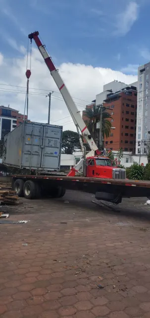 Camión grúa hidráulica sobre una plataforma en la ciudad