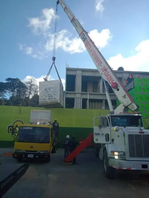 Camión con grúa hidráulica izando una carga