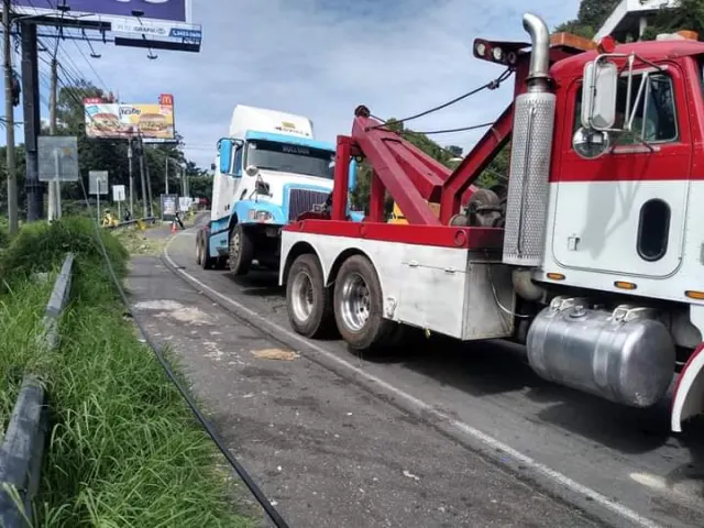 Grúa de arrastre pesada roja y blanca en carretera